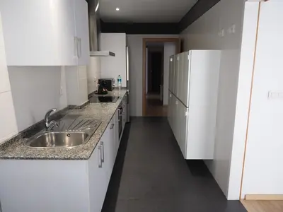 a kitchen with white cabinets and a sink at Rúa Mariñeiro in Burela de Cabo