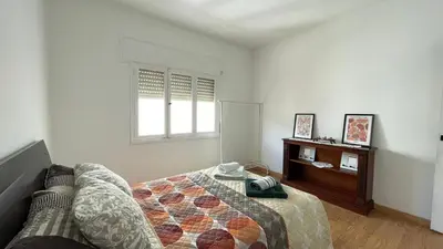 a bedroom with a bed and a dresser and a window at Apartamento céntrico in Burela de Cabo