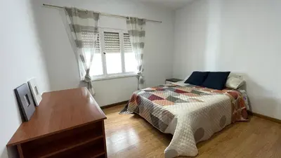a bedroom with a bed and a dresser and a window at Apartamento céntrico in Burela de Cabo