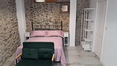 a bedroom with a bed and a chair at Casa Loma Lola in Molinaseca