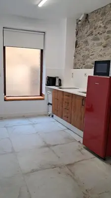 an empty kitchen with a red refrigerator and a window at Casa Loma Lola in Molinaseca