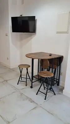 a wooden table with two chairs and a television on a wall at Casa Loma Lola in Molinaseca