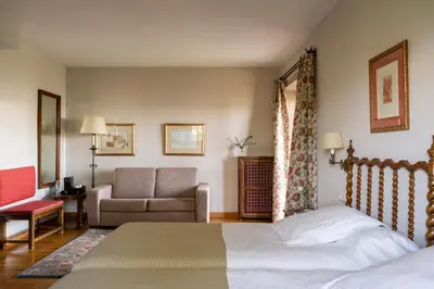 a bedroom with a bed and a couch and a chair at Parador de Verín in Monterrei