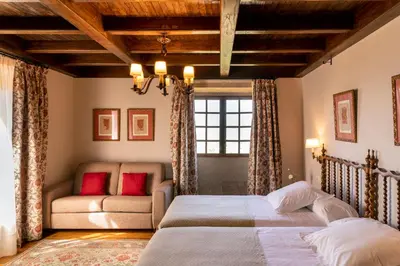 a bedroom with two beds and a couch at Parador de Verín in Monterrei