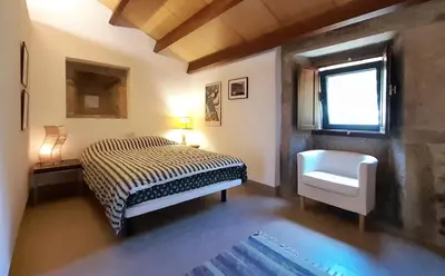a bedroom with a bed and a chair and a window at Pension Do Picho