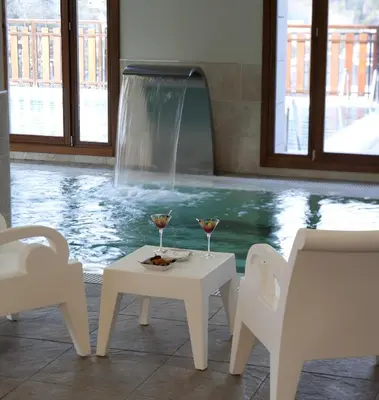 a table and two glasses of wine next to a swimming pool at Parador de Villafranca del Bierzo in Villafranca del Bierzo