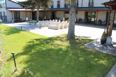 a courtyard with white chairs and a tree at Parador de Villafranca del Bierzo in Villafranca del Bierzo
