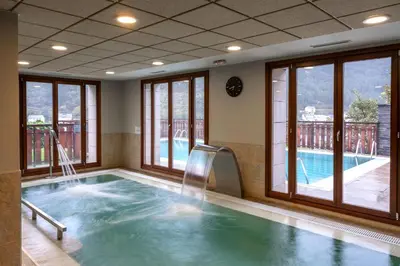 a swimming pool with a slide in a room with windows at Parador de Villafranca del Bierzo in Villafranca del Bierzo