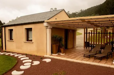 a house with a patio with chairs and a table at Apartamentos turísticos en la naturaleza in Barreiros