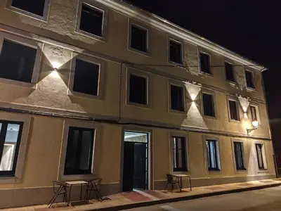 a building with two chairs in front of it at night at Hotel Casa dos Gardas in Samos