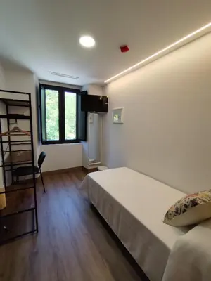 a bedroom with a bed and a desk and a window at Hotel Casa dos Gardas in Samos