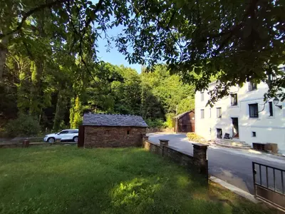 a building in the grass next to a street at Hotel Casa dos Gardas in Samos