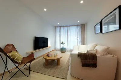 a living room with a couch and a table and a tv at Vita Homes by Upper Luxury Housing in Santiago de Compostela