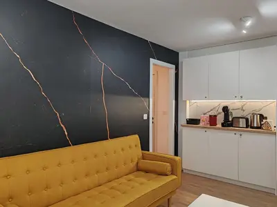 a living room with a couch and a black wall at Night Day in Padrón