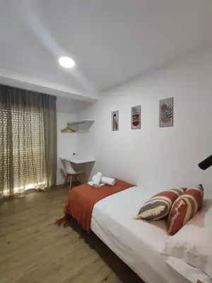 a bedroom with a large bed and a desk at Night Day in Padrón
