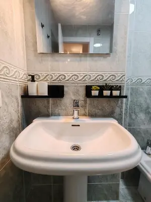 a white sink in a bathroom with a mirror at Night Day in Padrón