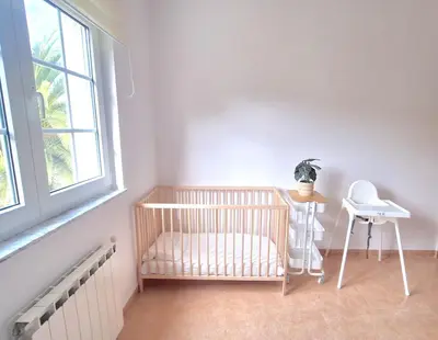 a room with a crib and a table and a window at Casa Naveira vistas mar en Foz in Foz
