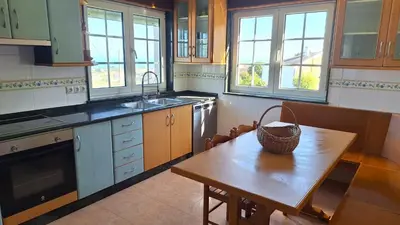 a kitchen with a wooden table with a basket on it at Casa Naveira vistas mar en Foz in Foz