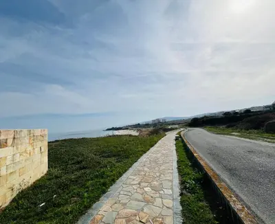 a road next to the ocean on a cloudy day at Casa Naveira vistas mar en Foz in Foz