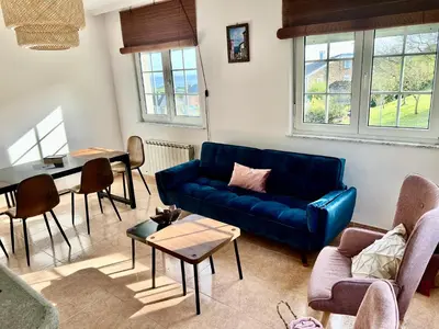 a living room with a blue couch and a table at Casa Naveira vistas mar en Foz in Foz