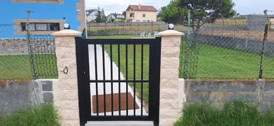 a gate in a fence with a dog inside at Casa Julia in Barreiros