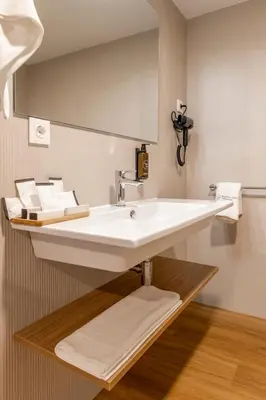 a bathroom with a white sink and a mirror at SNÖ Porta das Fragas in A Capela