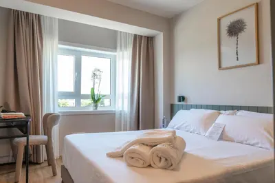 a bedroom with a bed with towels on it at SNÖ Porta das Fragas in A Capela