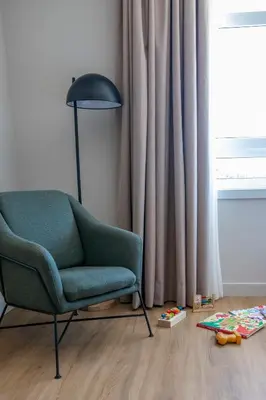 a living room with a green chair and a lamp at SNÖ Porta das Fragas in A Capela