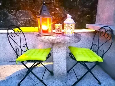 two chairs and a table with a lantern at La Casa del Bosque del Agua y SPA Prexigueiro Obsequio entrada por persona a circuito termal in Mondariz
