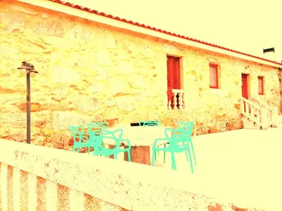 a patio with chairs and a table in front of a building at La Casa del Bosque del Agua y SPA Prexigueiro Obsequio entrada por persona a circuito termal in Mondariz