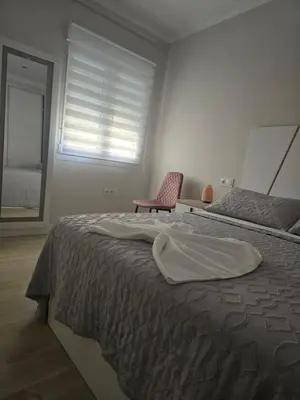 a bedroom with a bed and a chair and a window at Piso Bedoya in Ourense