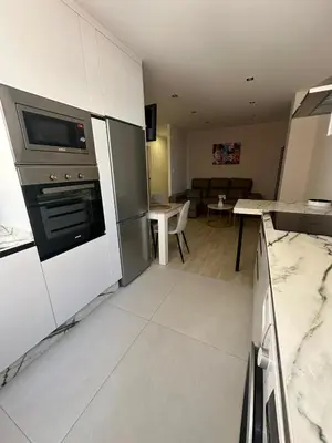 a kitchen with a stove and a living room at Piso Bedoya in Ourense