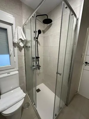 a bathroom with a glass shower with a toilet at Piso Bedoya in Ourense