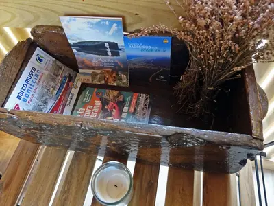 a wooden table with books and a vase of flowers at Suit Cabozo de Rexa in Barral