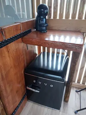 a small refrigerator under a wooden table with a bench at Suit Cabozo de Rexa in Barral