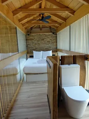 a small room with a bed and a toilet at Suit Cabozo de Rexa in Barral