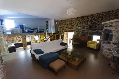 a living room with a bed and a stone wall at Casa Vaz in A Estrada