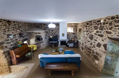 a living room with a stone wall at Casa Vaz in A Estrada