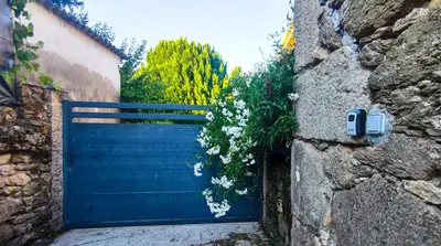 a blue garage door in a stone wall at Casa Vaz in A Estrada