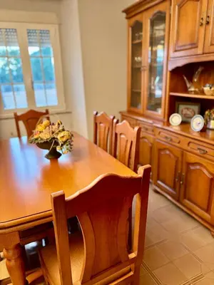 a dining room table with a vase of flowers on it at Aloe Cela in Outeiro de Rei