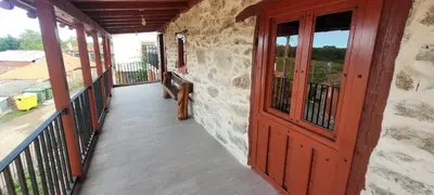 a porch with a red door and a balcony at Casa Otero in Serode