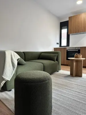 a living room with a green couch and a table at Lemos Lar in Monforte de Lemos