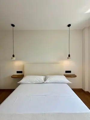 a bedroom with a large white bed with two lights at Lemos Lar in Monforte de Lemos