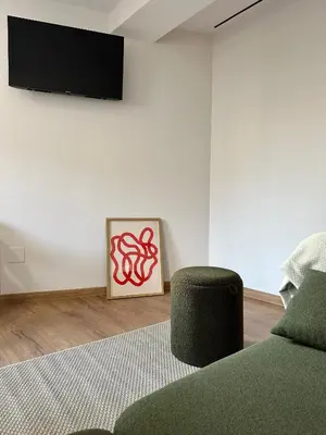 a living room with a couch and a television on a wall at Lemos Lar in Monforte de Lemos