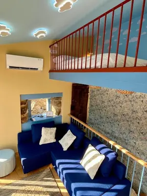 a blue couch in a living room with a staircase at Casa ATURUXIÑO in Belesar