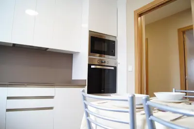 a kitchen with a microwave and a table with chairs at Fin del Camino in Santiago de Compostela