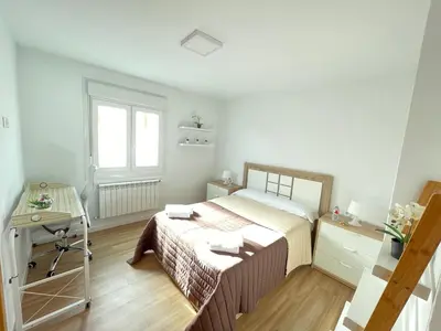 a bedroom with a bed and a desk and a window at Fin del Camino in Santiago de Compostela