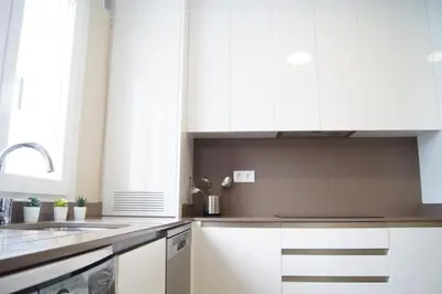 a kitchen with white cabinets and a sink at Fin del Camino in Santiago de Compostela