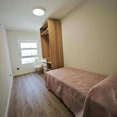 a bedroom with a bed and a window and a chair at Manisa I in Ribadeo