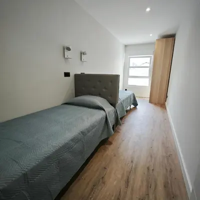 a bedroom with a bed and a wooden floor at Manisa I in Ribadeo